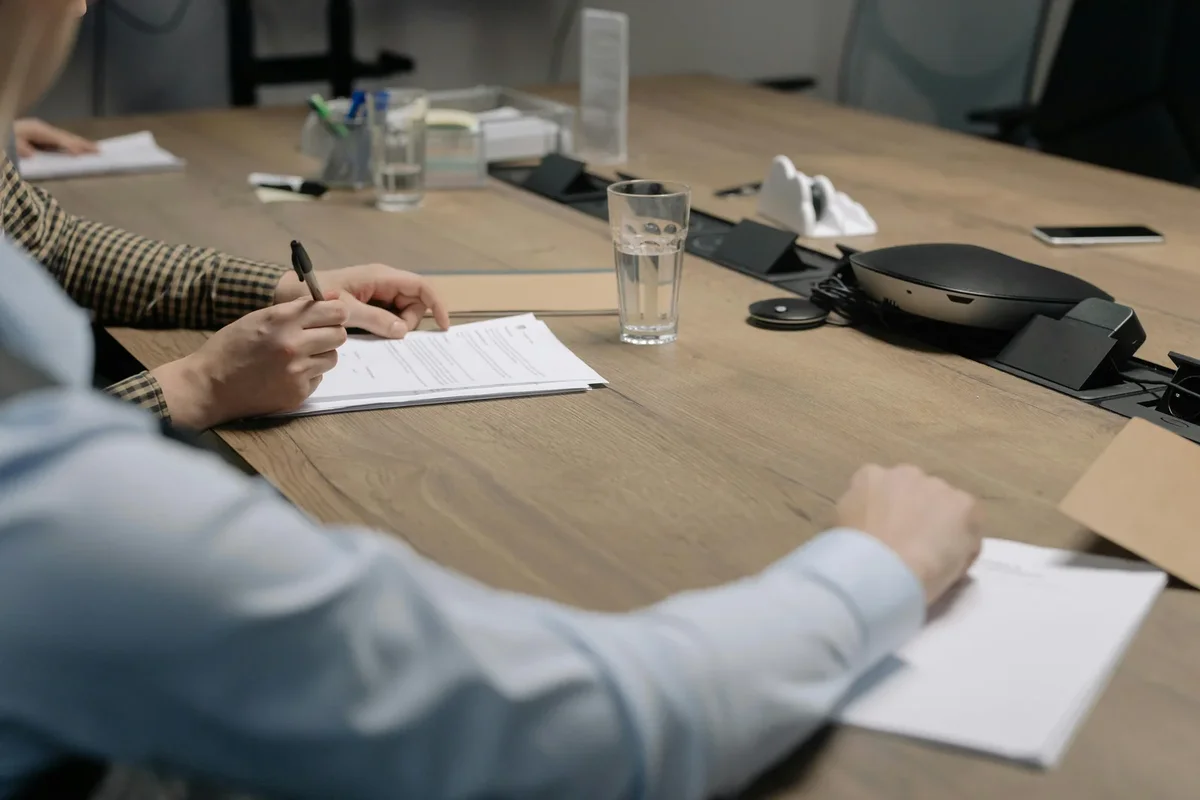 Réunion d'affaires où un accord légal est signé par plusieurs participants