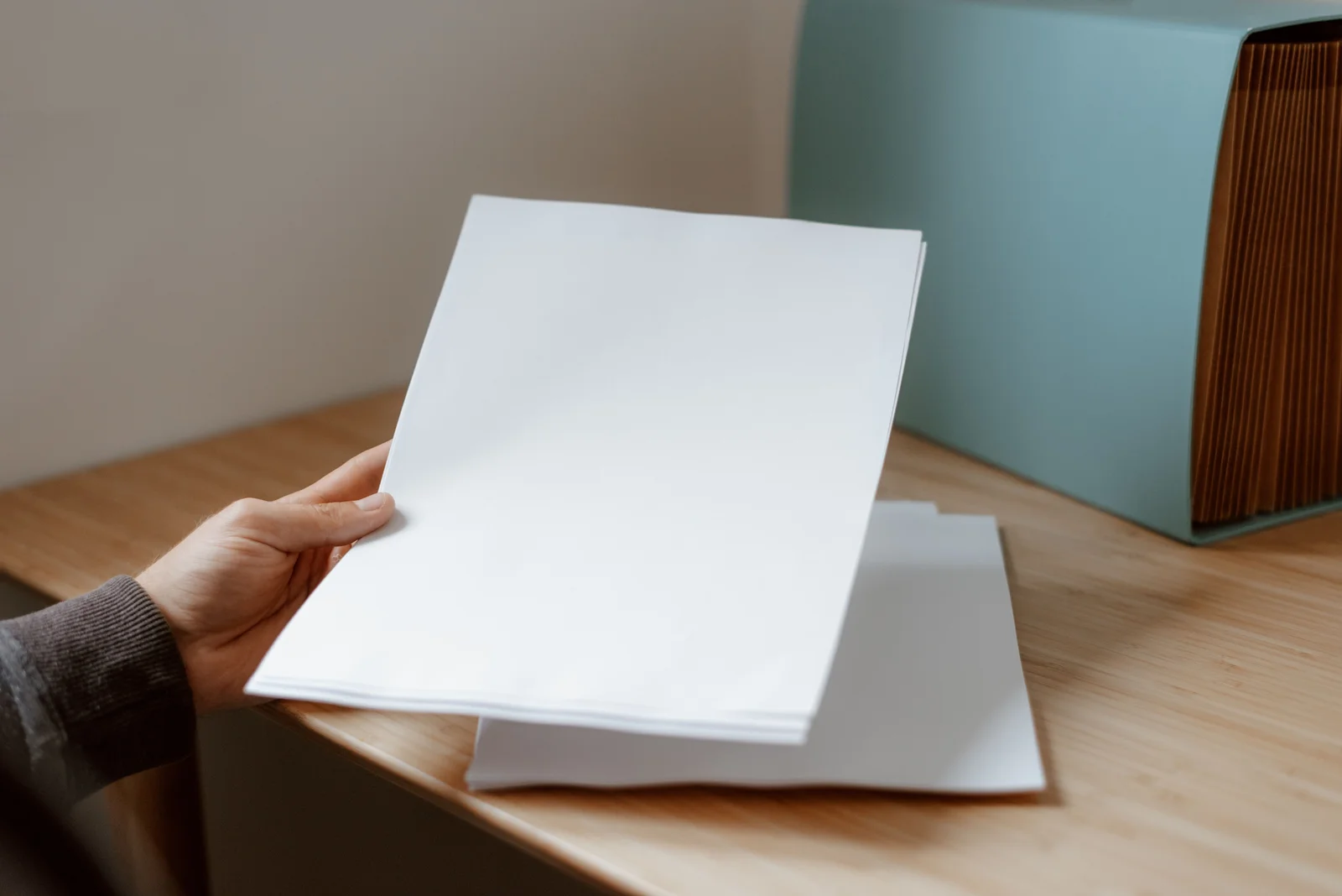 Personne classant des documents administratifs dans des pochettes sur un bureau