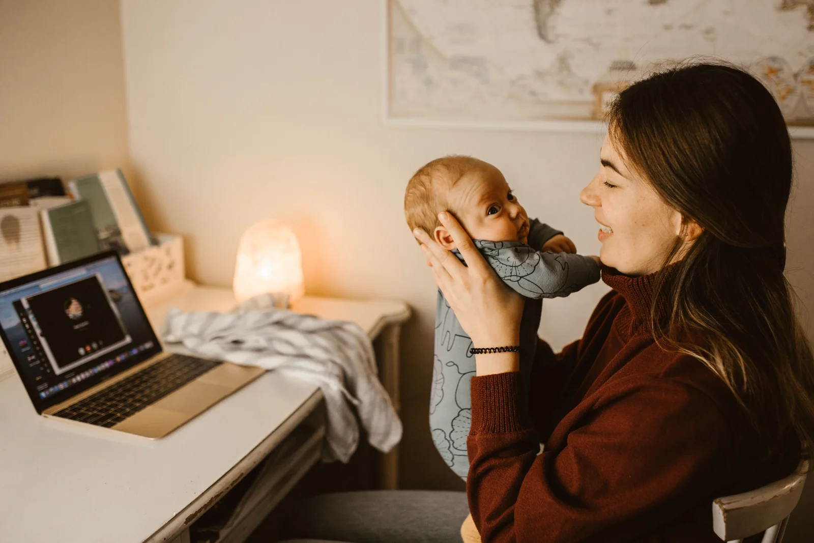 Mère travaillant sur son ordinateur à la maison avec son bébé à côté d'elle