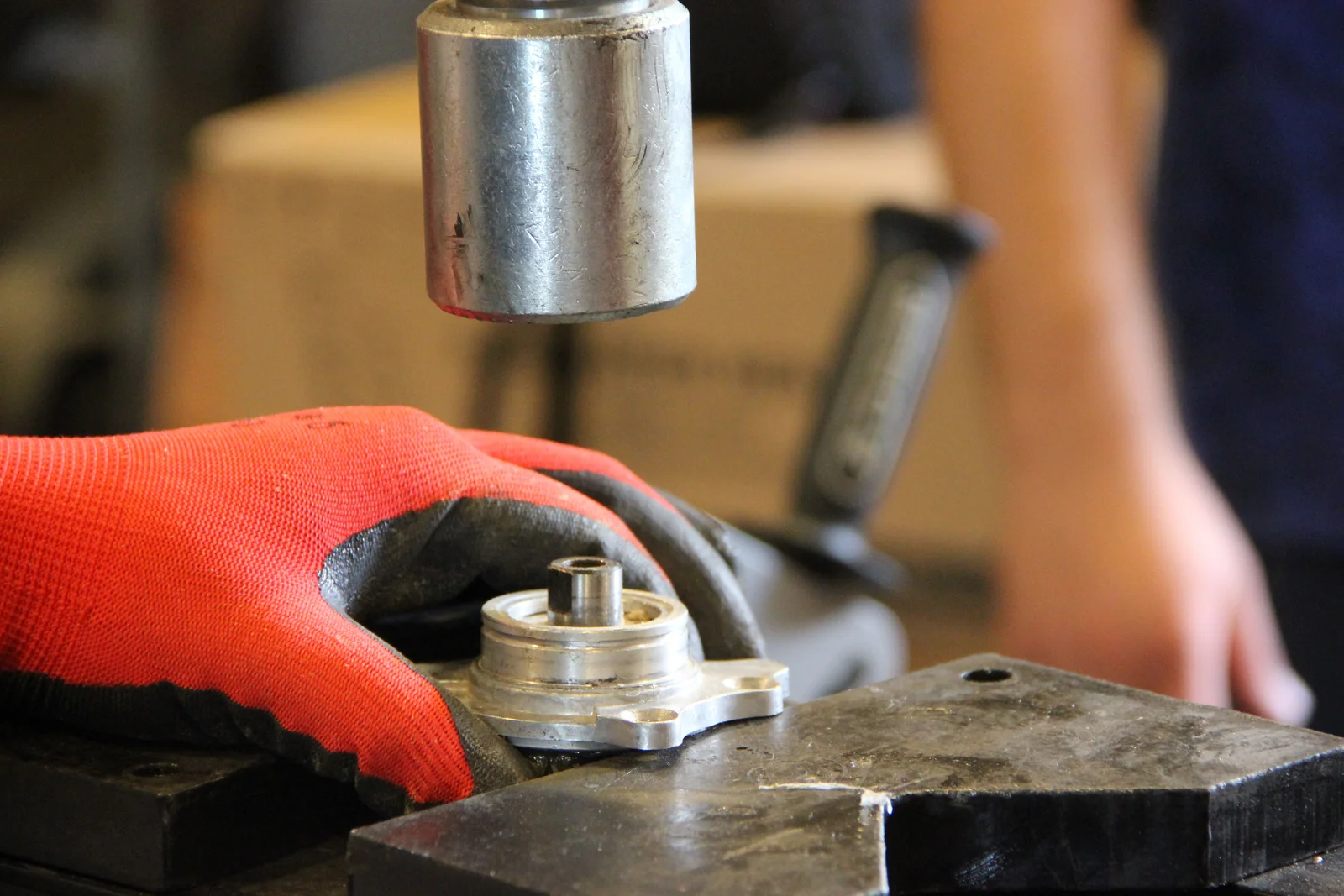 Mains gantées d'un ouvrier maniant des outils sur un établi